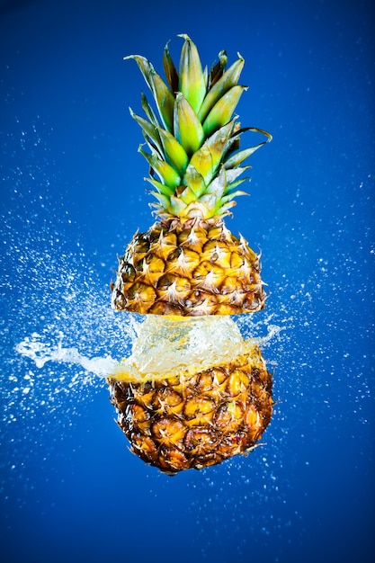 Ananas spruzzato con acqua su sfondo blu