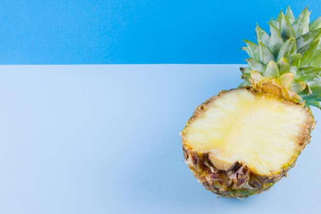 Ananas su sfondo blu Mezz'ananas su fondo pastello Copia spazio