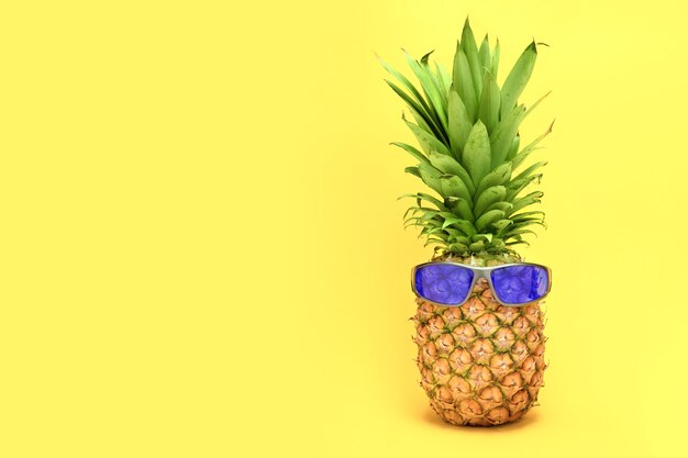 Ananas su sfondo giallo con gli occhiali