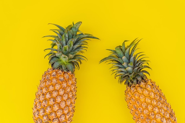 Ananas su sfondo giallo concetto estivo piatto vista dall'alto