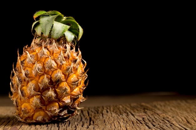 Ananas su vecchio legno. sfondo nero