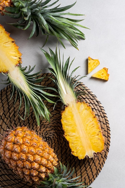 Ananas tagliato fresco con foglie tropicali su sfondo blu scuro