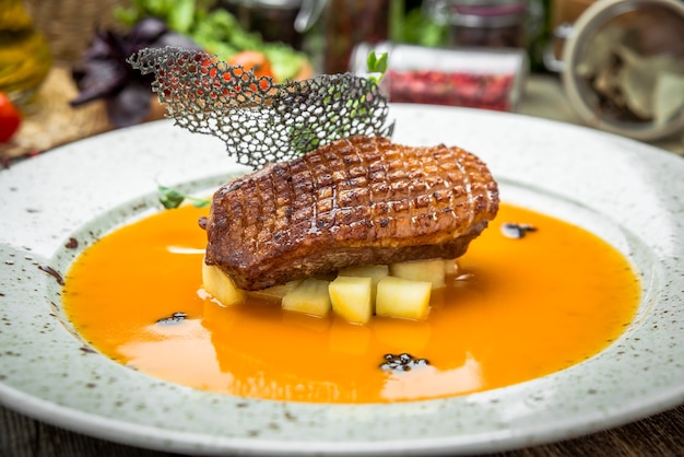 Anatra affumicata alla griglia con salsa gialla mangiare con insalata verde, su un tavolo di legno