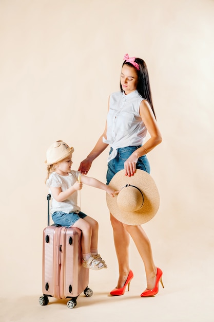 Andare all'avventura. Famiglia felice preparando per il viaggio. Mamma e figlia stanno facendo le valigie per il viaggio.