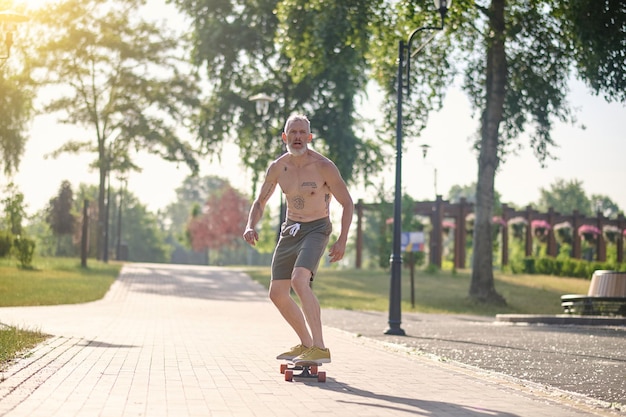 Andare con lo skateboard. Uno skateboarder maschio che guida uno skateboard e mantiene l'equilibrio