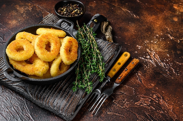 Anelli di calamari fritti impanati su un tagliere