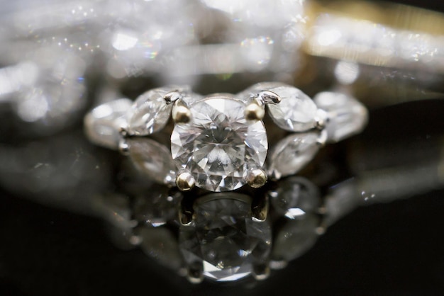 Anelli di diamanti gioielli in oro di lusso con riflessione su sfondo nero
