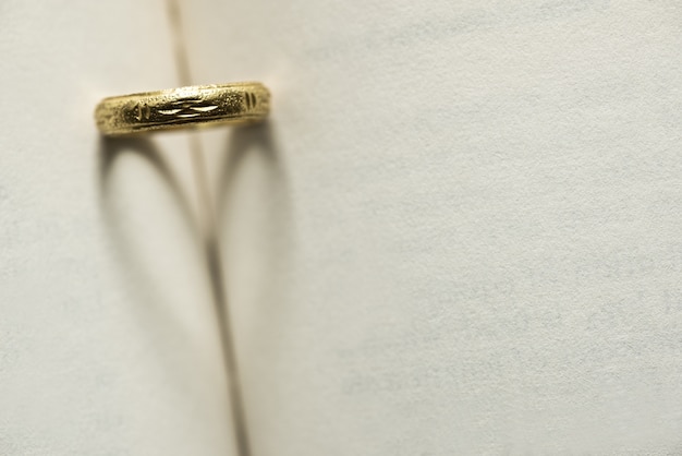 anello d&#39;oro con ombra a forma di cuore sulla pagina del libro