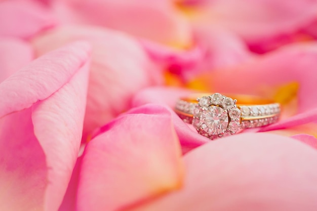 Anello di diamanti gioielli su sfondo bellissimo petalo di rosa rosa