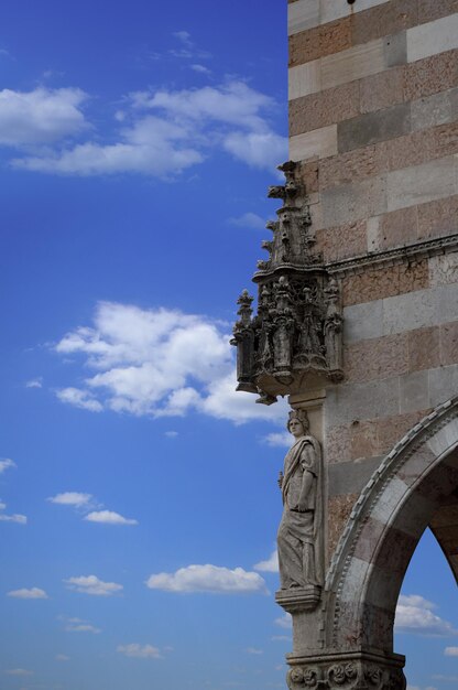 Angolo di un antico edificio in stile romano contro un cielo blu