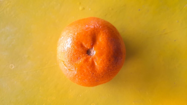 Angolo superiore, frutta arancione fresca su sfondo giallo