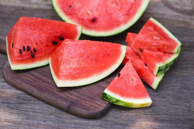 Anguria affettata sul fondo di legno del tagliere - frutta tropicale dell'estate dei pezzi freschi dell'anguria da vicino