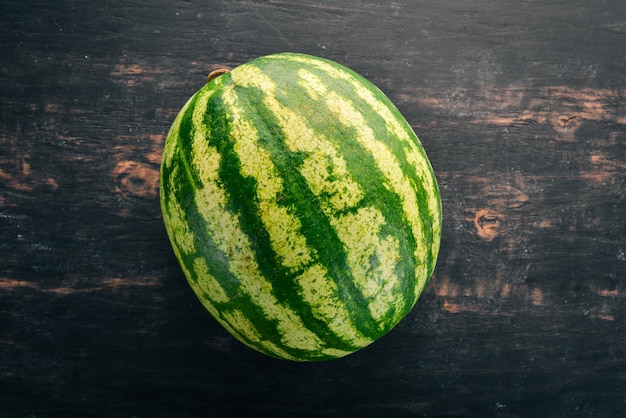 Anguria fresca Frutti Melone Su uno sfondo di legno nero Spazio libero per il testo Vista dall'alto