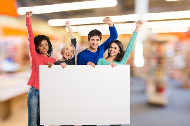 Anni dell'adolescenza in possesso di banner in bianco e sorridente