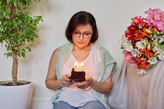 Anniversario di celebrazione di compleanno Donna di 45 anni con piccola torta con candele accese