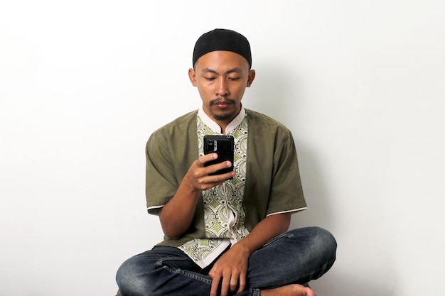 Annoiato durante il Ramadan, un uomo indonesiano controlla il telefono