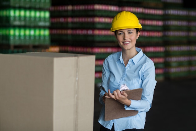 Annotazione di mantenimento dell'operaio femminile sulla lavagna per appunti in fabbrica