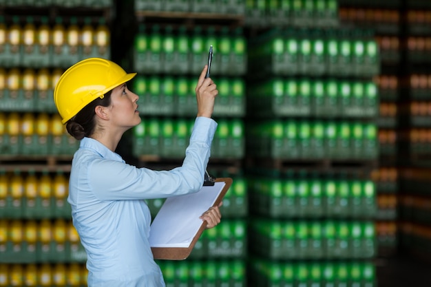 Annotazione di mantenimento dell'operaio femminile sulla lavagna per appunti in fabbrica