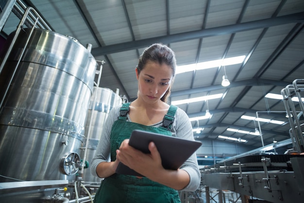 Annotazione di mantenimento dell'operaio femminile sulla lavagna per appunti in fabbrica