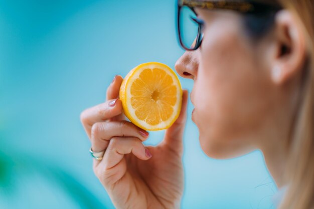 Anosmia o cecità dell'odore uno dei sintomi della covid-19 donna che cerca di sentire l'odore di un limone