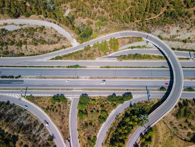 Antenna della giunzione autostradale multilivello europea con automobili attraverso la foresta a Salonicco Grecia