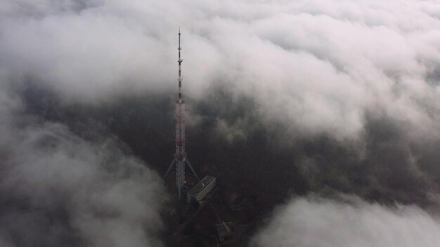 Antenna della torre della televisione nella nebbia alla vista aerea del giorno d'estate