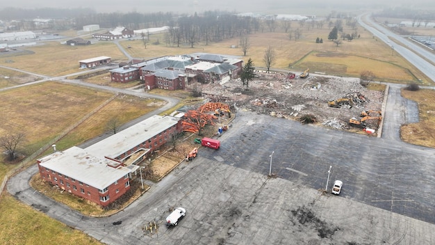 Antenna drone di una grande zona di costruzione mentre il vecchio edificio ospedaliero abbandonato subisce la decostruzione