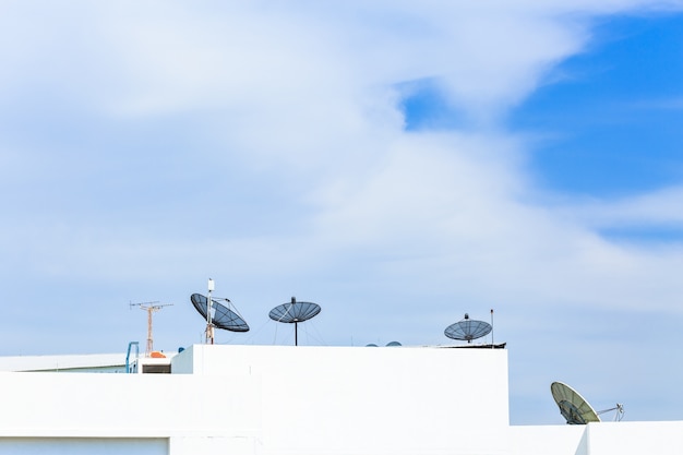 Antenna parabolica in cima all&#39;edificio in area urbana a mezzogiorno