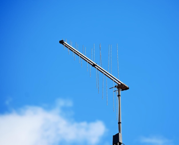 Antenna TV sotto un cielo blu con nuvole