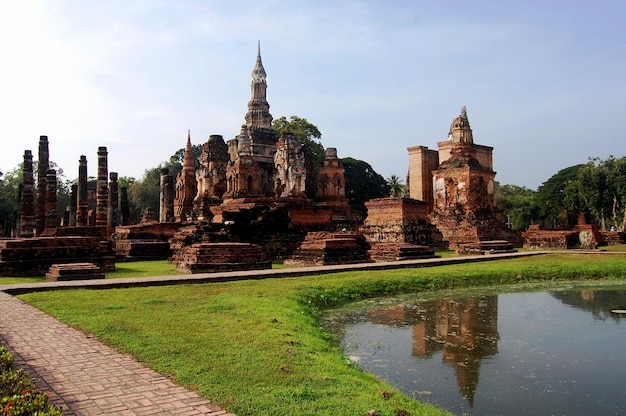 Antica architettura dell'antichità e antiche rovine di edifici per i viaggiatori thailandesi che viaggiano visitano il rispetto pregando al parco storico di Si Satchanalai e patrimonio mondiale dell'UNESCO a Sukhothai Thailandia