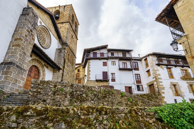 Antica chiesa in pietra e case con balconi in legno nel grazioso villaggio di Candelario Salamanca