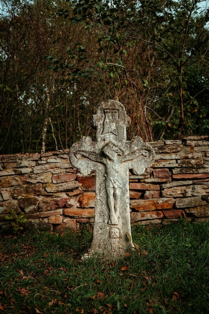 Antica croce di pietra su una tomba in memoria di un cimitero abbandonato 1