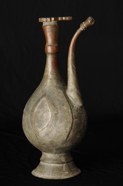 Antica teiera in metallo orientale su sfondo scuro stoviglie in bronzo antico