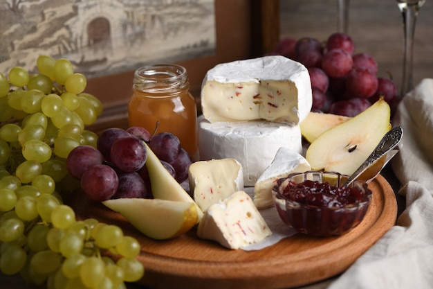 Antipasti. Camembert di formaggio con uva, pere a fette e confettura, un ottimo antipasto per il vino.