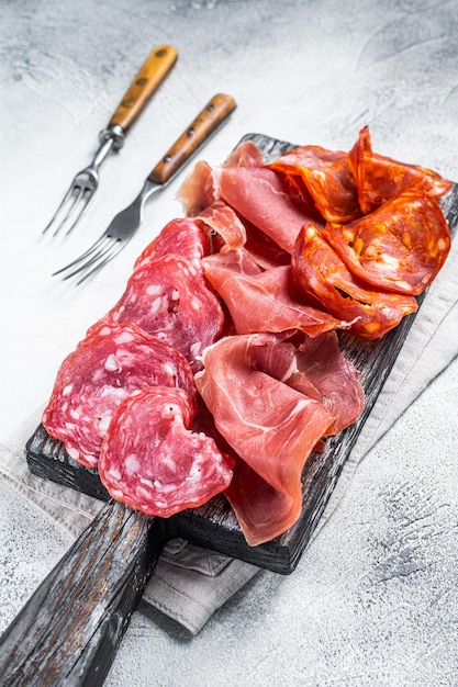 Antipasti di carne assortiti - salame, jamon, choriso. Sfondo bianco. Vista dall'alto.