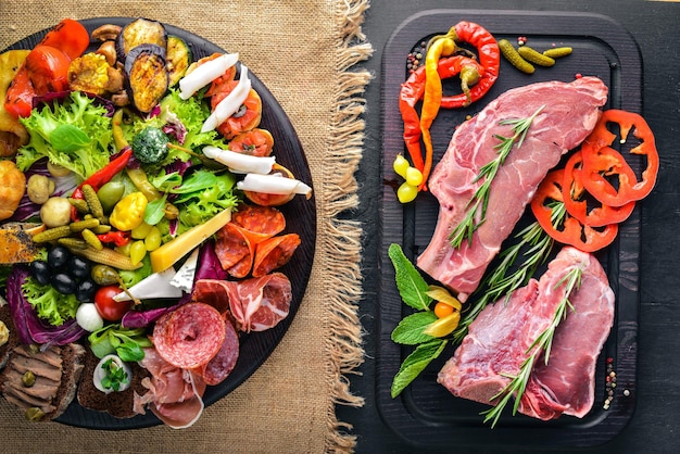 Antipasti freddi, carne e sottaceti. Bistecca di carne. Cucina italiana. Vista dall'alto. Su Fondo In Legno.