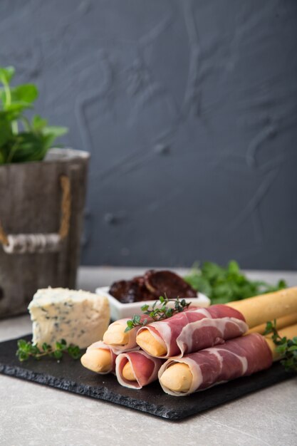 Antipasto con prosciutto, prosciutto, formaggio blu e pomodori secchi per le vacanze