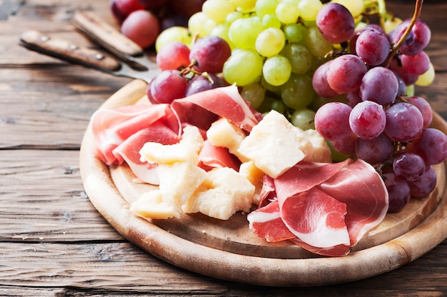 Antipasto con uva, formaggio e prosciutto