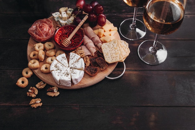Antipasto di vino salumi e formaggio piatto vista dall'alto su sfondo di legno