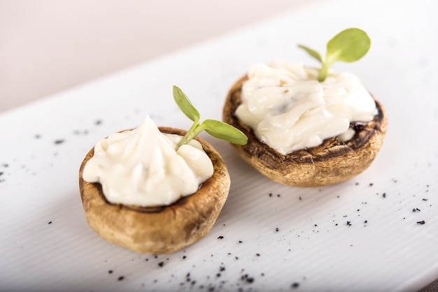 Antipasto fresco con funghi, ripieno di maionese, decorato con foglia verde