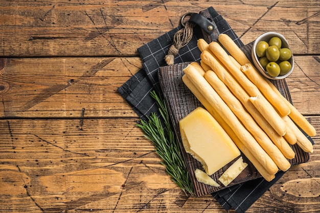 Antipasto italiano tradizionale grissini grissini su tavola di legno con olive e parmigiano Bakground in legno Vista dall'alto Spazio di copia