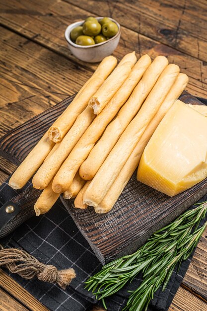 Antipasto italiano tradizionale grissini grissini su tavola di legno con olive e parmigiano Bakground in legno Vista dall'alto