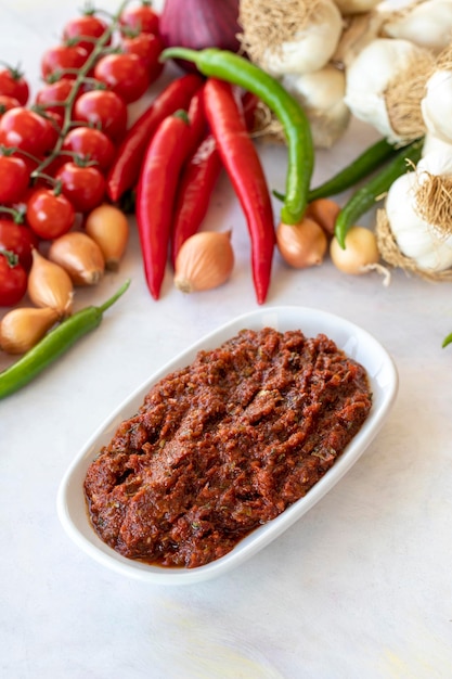 Antipasto piccante schiacciata o adjika harissa fatta con pomodoro, aglio, cipolla, pasta di peperoni e olio d'oliva Sapori della cucina tradizionale mediorientale Spuntino vegetariano sano con piatto principale Acili ezme