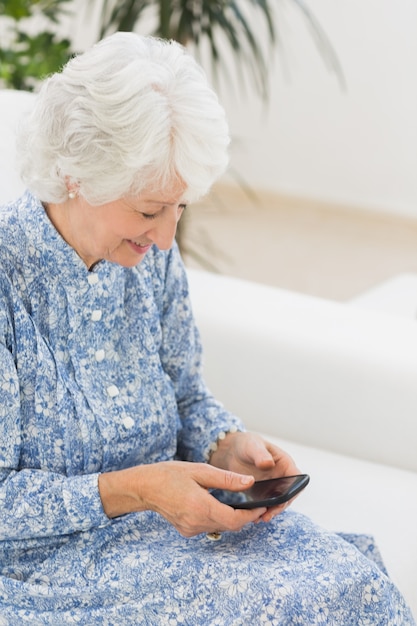 Anziana donna felice utilizzando uno smartphone