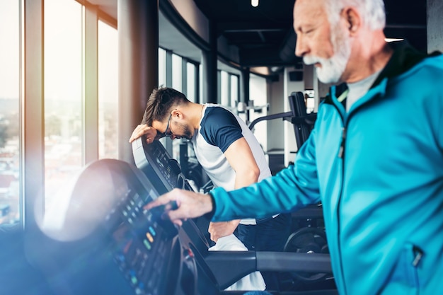 Anziani e giovani sportivi che si esercitano in palestra.