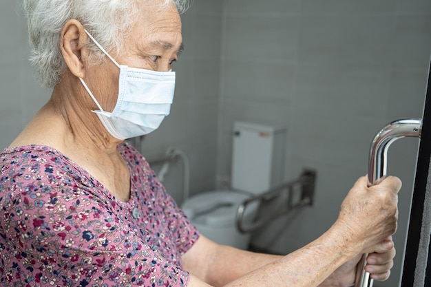 Anziano asiatico o anziano donna paziente uso wc bagno maniglia sicurezza in reparto di cura sana e forte concetto medico