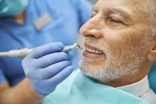 anziano che si fa lucidare i denti con un brunito odontoiatrico