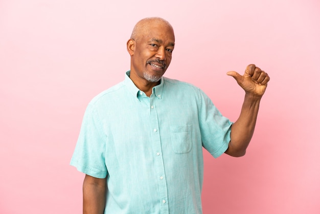 Anziano cubano isolato su sfondo rosa orgoglioso e soddisfatto di sé