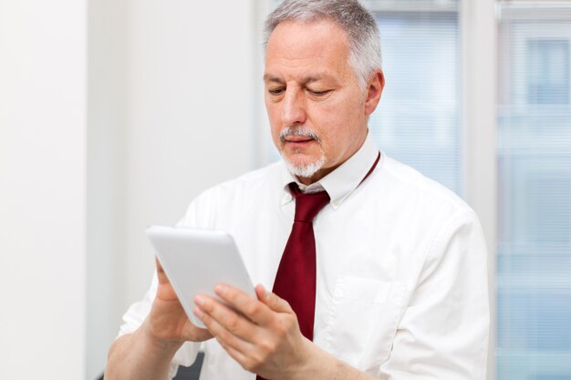 Anziano uomo d&#39;affari con il suo tablet