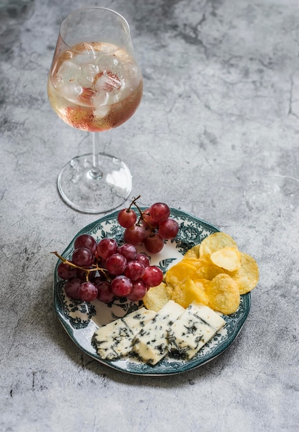 Aperitivo antipasti di tapas cocktail e piatto con formaggio d'uva e patatine fritte su sfondo grigio vista dall'alto